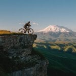 man riding bike on cliff at daytime